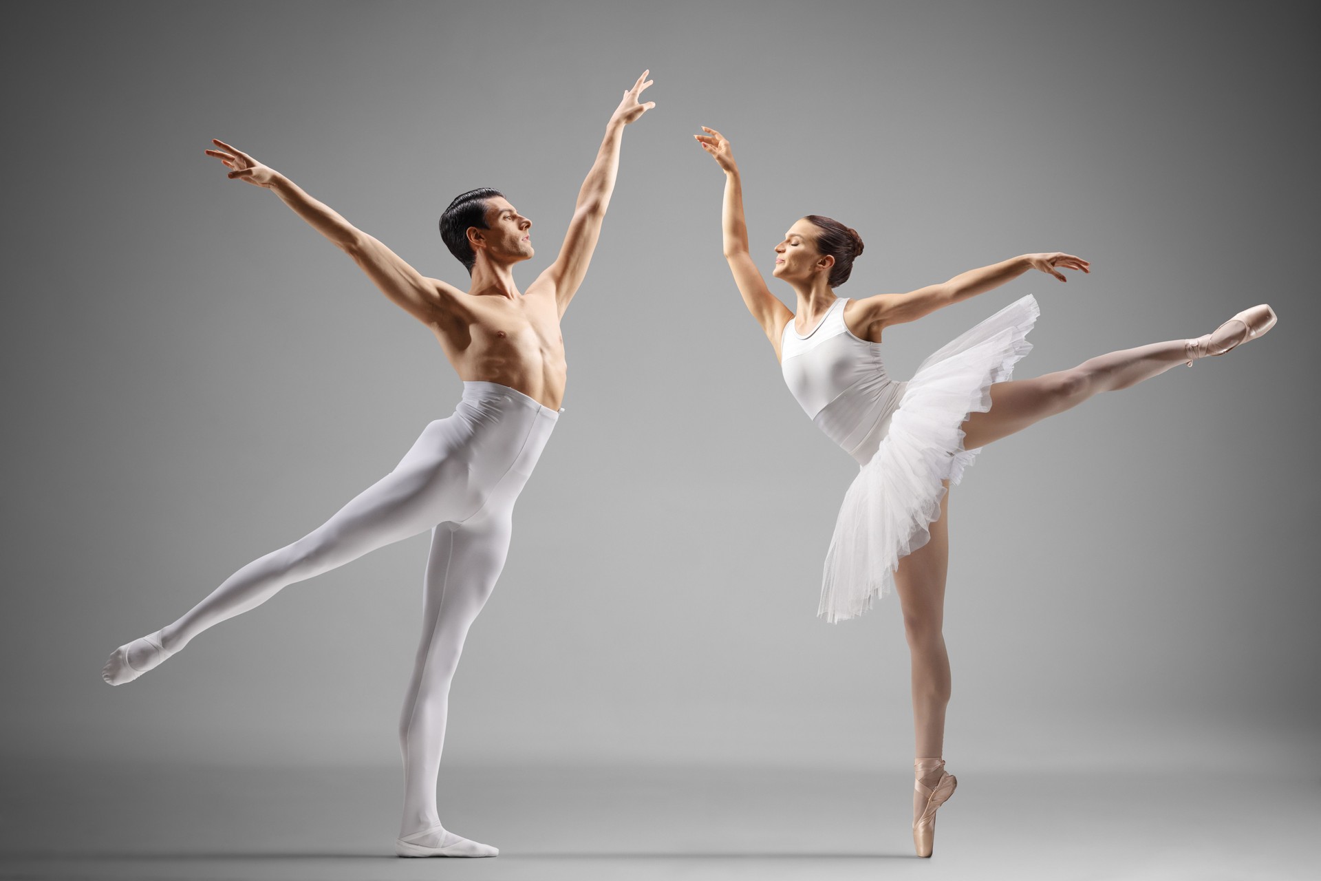 Bailarín de ballet masculino con medias blancas y bailarina bailando