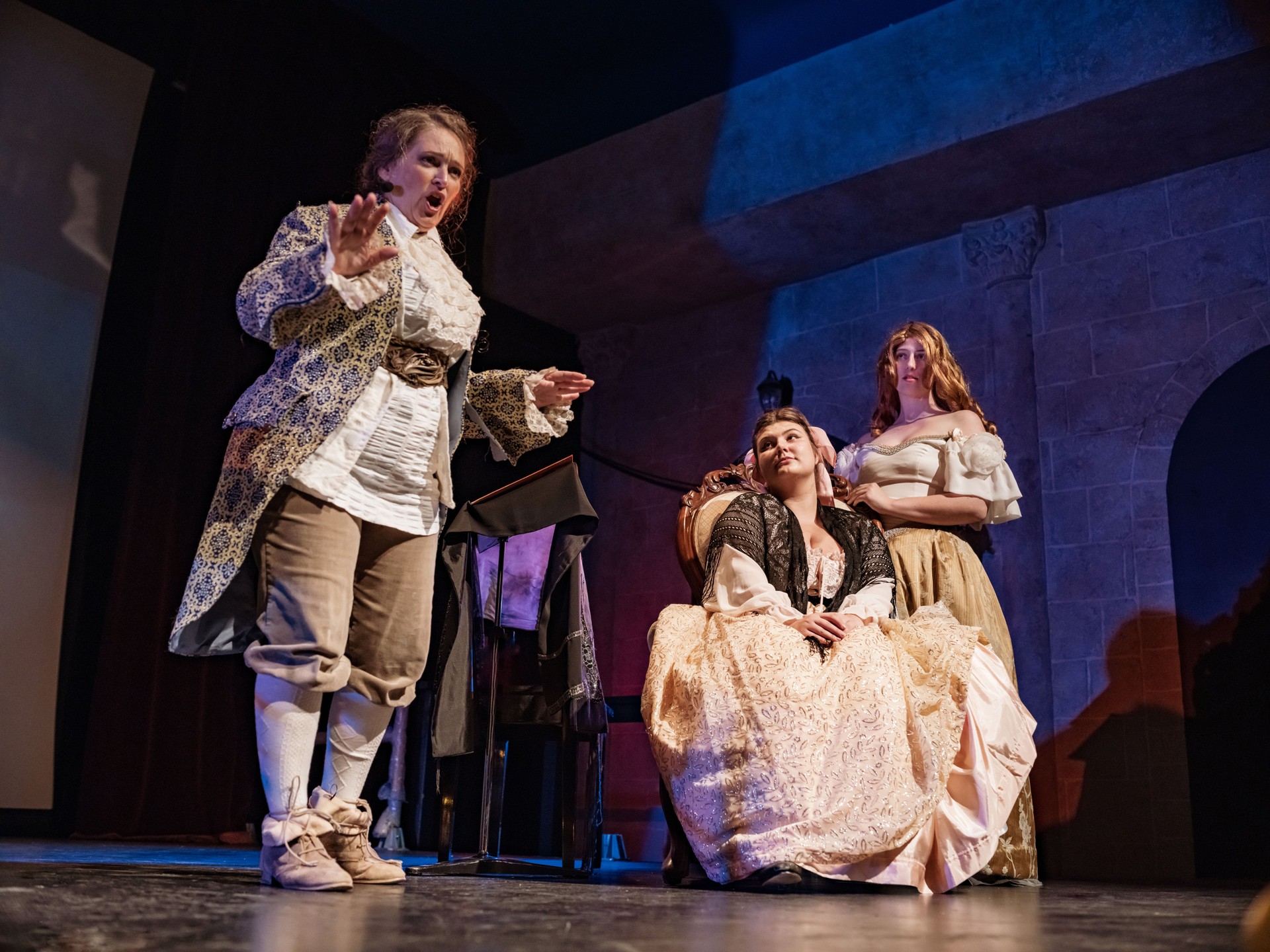 Tres actrices con trajes de época en el escenario del teatro